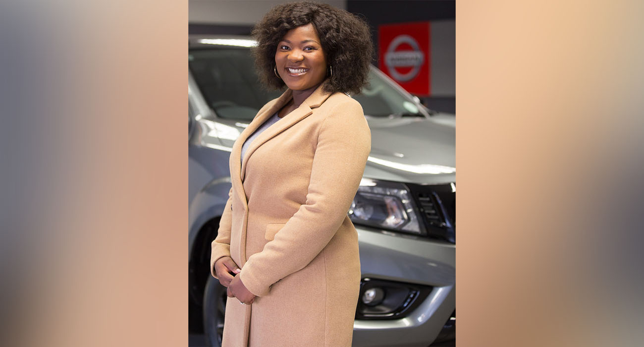 Chantelle Nkosi posing in front of a nissan vehicle with her hands crossed.