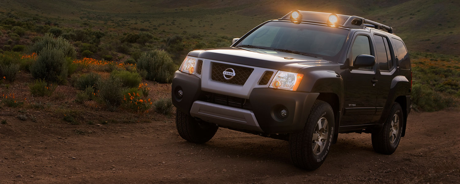 A 2009 Xterra driving off-road with roof lights on