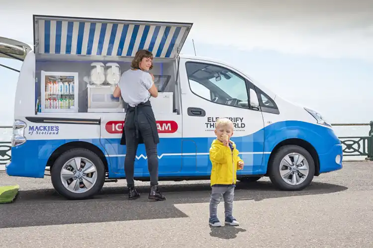 señora y niño a lado de una van eléctrica de helados