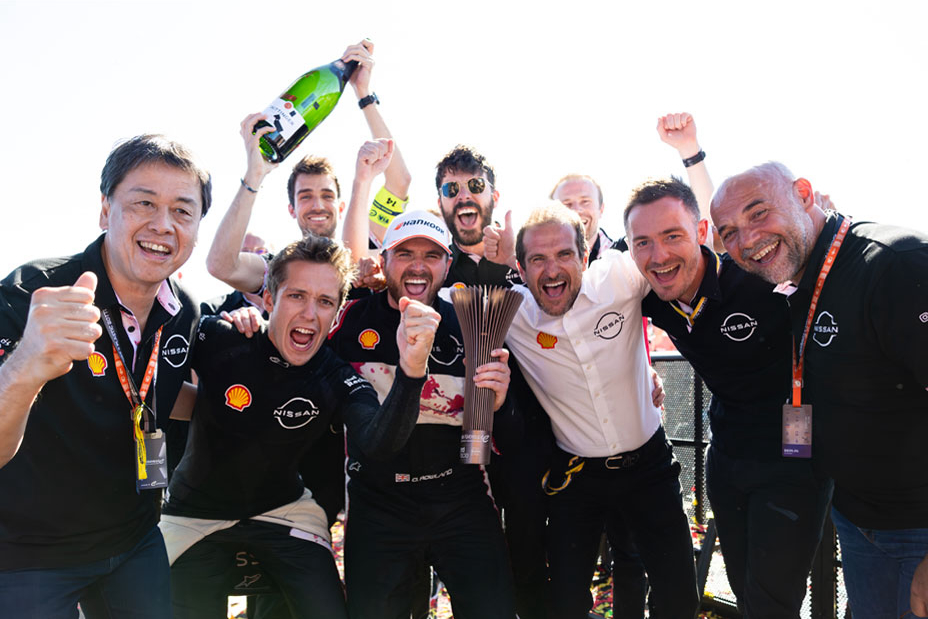 Nissan Formula E Team members and Nissan CEO Makoto Uchida celebrate Oliver Rowland's podium finish in Berlin