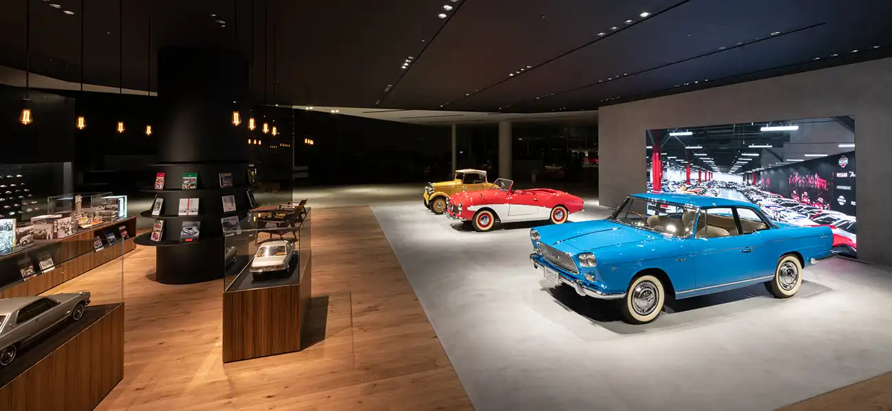 Three vintage cars in indoor exhibit