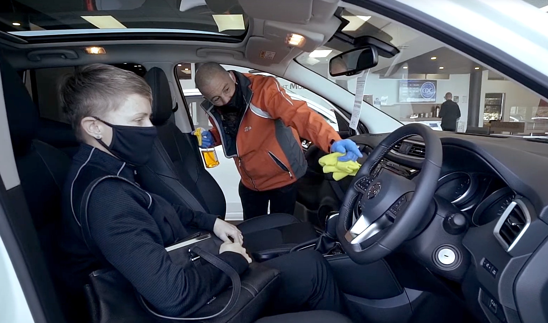 Nissan employee disinfecting the inside of a car.