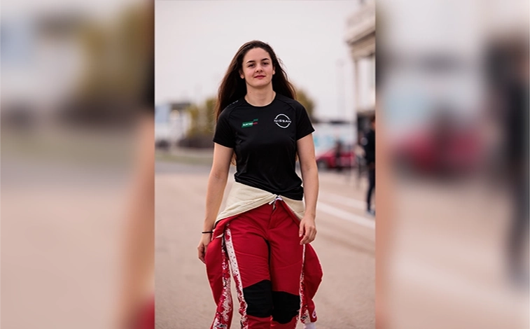 Nissan Formula E Team simulator & rookie driver Abbi Pulling walking with a race suit partially on