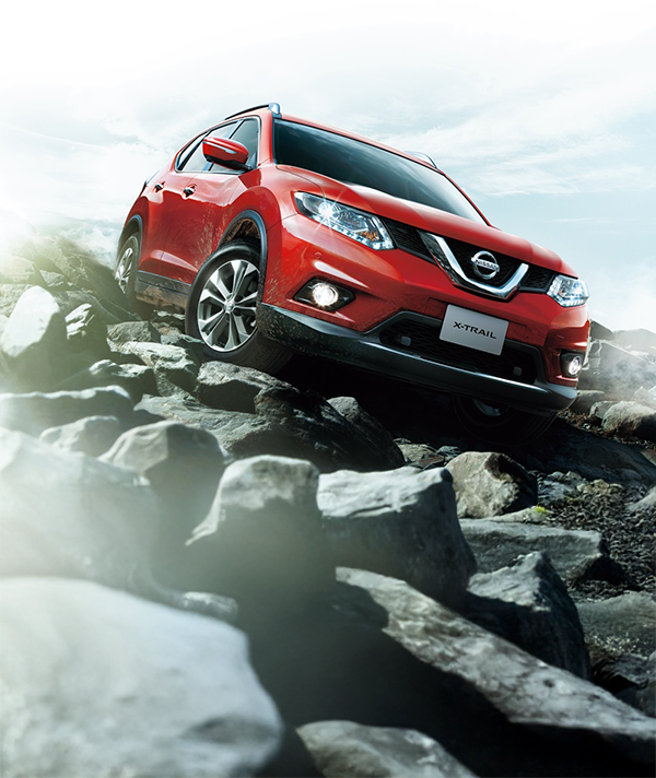 A lineup of red Nissan X-Trails with a sunset behind them.