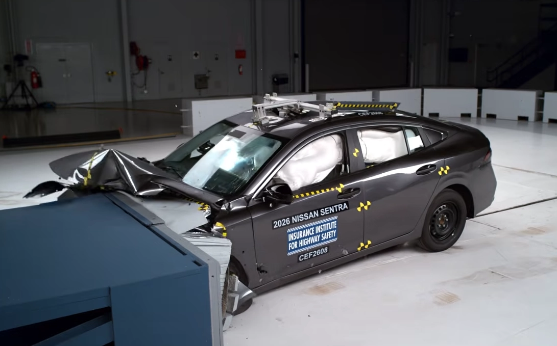 A test vehicle that has struck and object, the hood is caved in, testing stickers are visible.