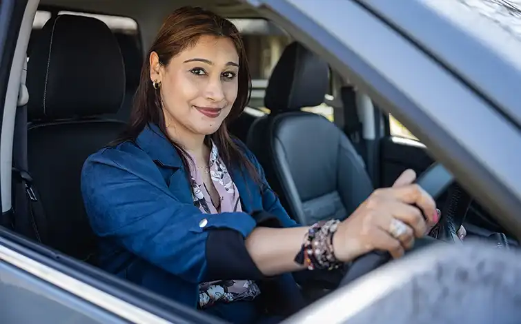 Asha Sivenath sitting in the driver's seat.