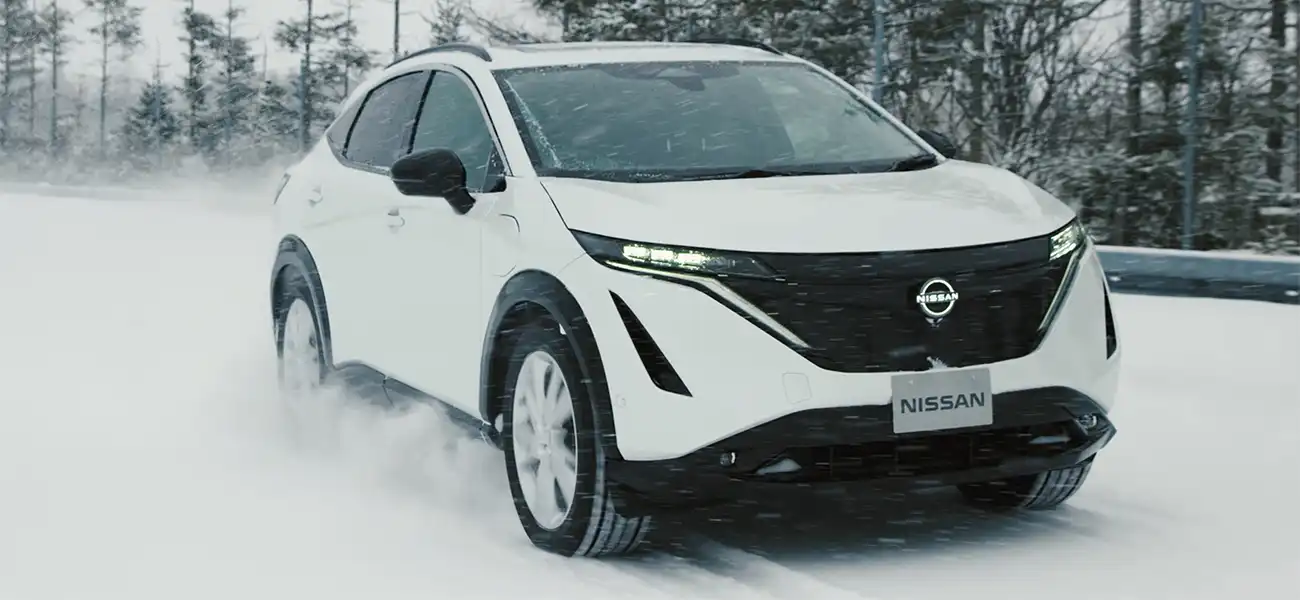 White vehicle driving through snow