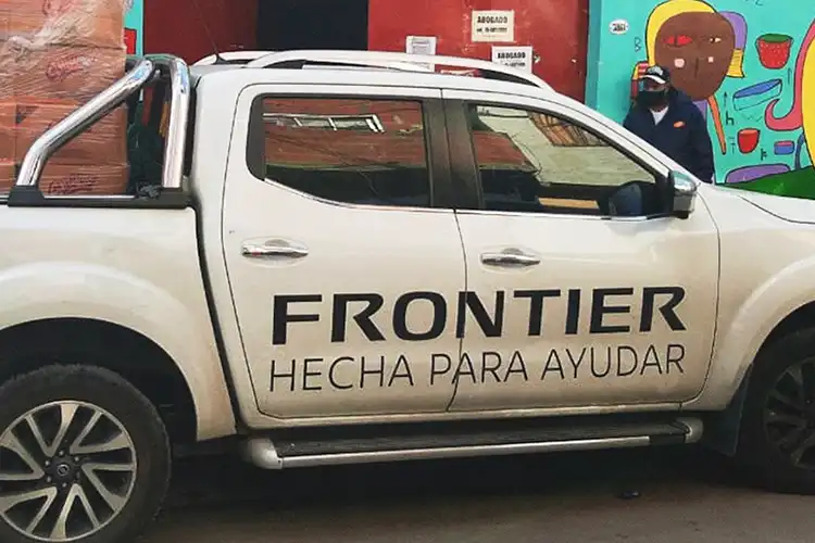 Una camioneta Nissan Frontier estacionada frente a un edificio con pinturas coloridas
