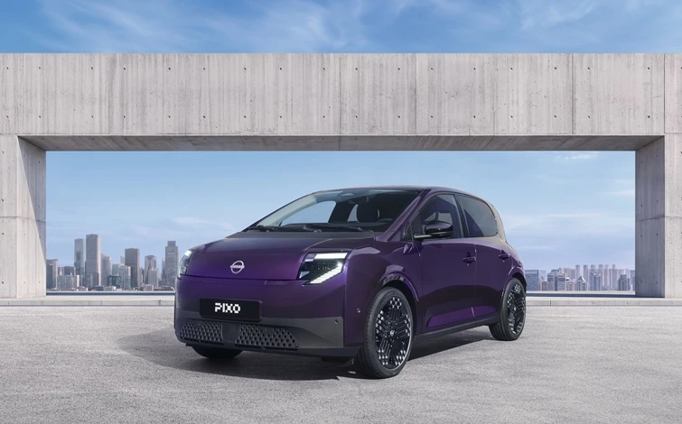 紫色の新型小型EV「ピクソ」を前方斜めから捉えた外観写真。モダンなコンクリート構造物の下に停車し、背景には青空を臨む都市の風景が広がる。