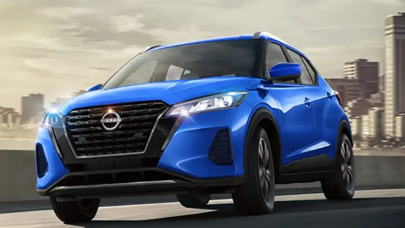 Nissan Kicks azul estacionada de frente, al fondo edificios.