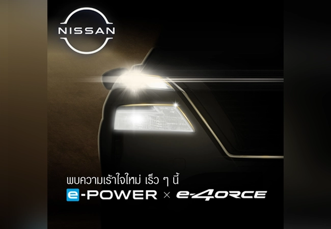 A close-up of a Nissan car's headlight glowing in the dark, with the Nissan logo and Japanese text promoting its electric technologies: e-POWER and e-4ORCE.