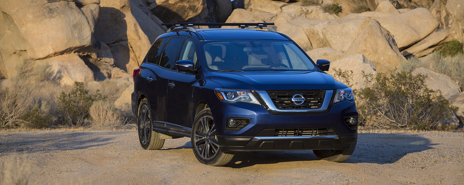 A blue 2017 Nissan Pathfinder parked off-road in desert setting