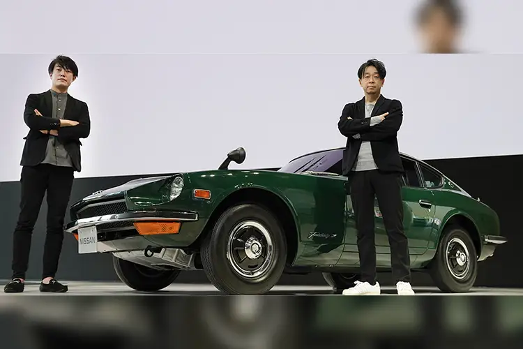 Naoyuki Ohkoshi and Takuya Yamashita posing in front of a green Nissan vehicle