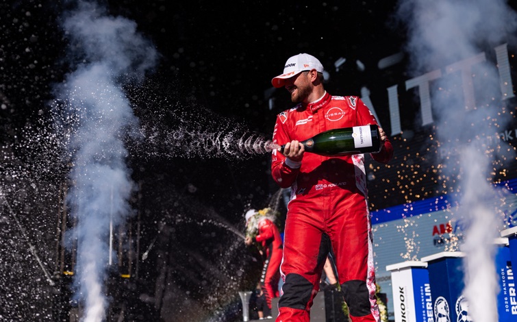ベルリン大会の表彰台で、2位フィニッシュを果たし、シャンパンを振りまいて祝う日産フォーミュラEチームのドライバー、オリバー ローランド