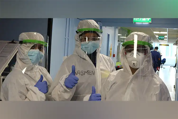 Tres personas con equipo de protección en un entorno médico