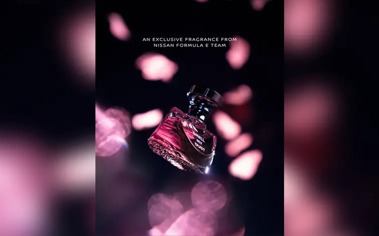 Cartaz de promoção do perfume criado pela Equipe Nissan de Fórmula mostra o vidro da fragrância segurado por uma mão