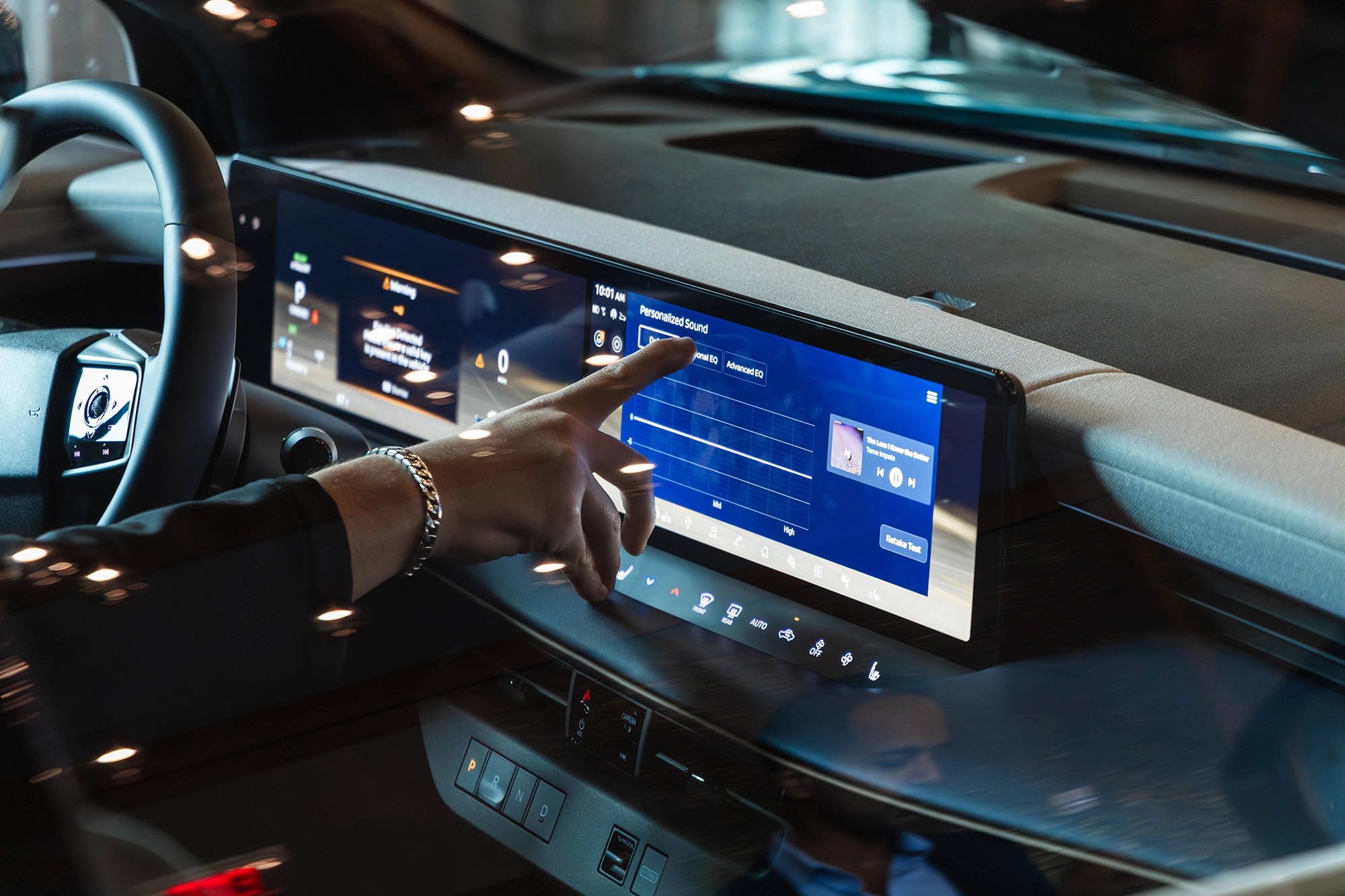 Angled view of a finger hovering over an infotainment screen to press touch screen call to actions.