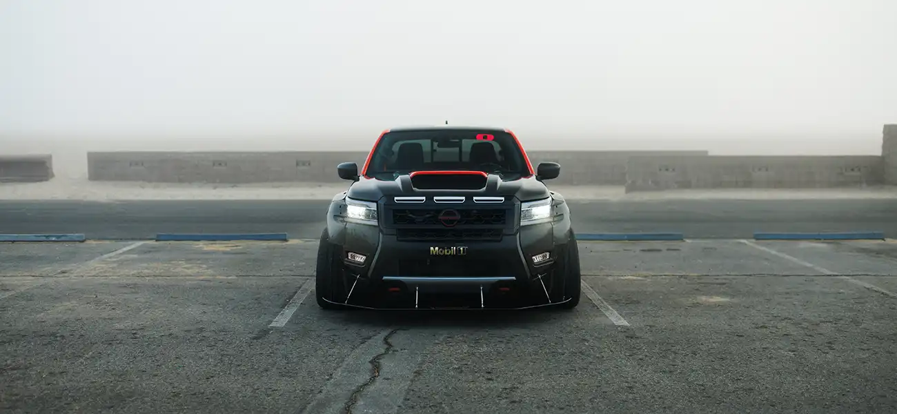 Front view of the Nissan Frontier Tarmac, parked in a lot on a foggy day.