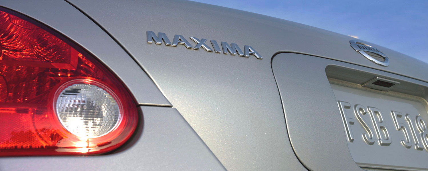 A silver Nissan Maxima rear badge