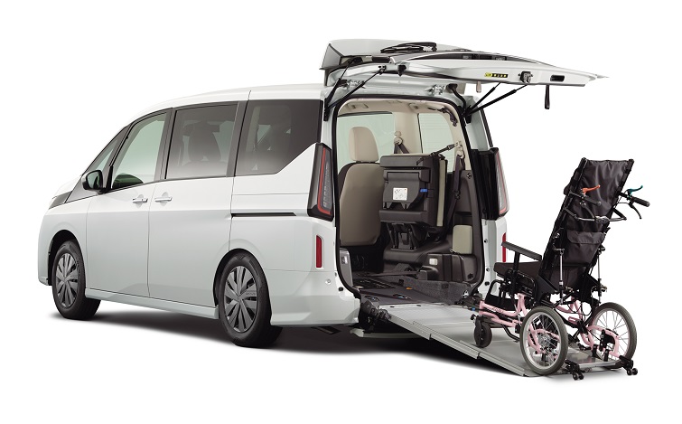 白いセレナ_チェアキャブ_スロープタイプの車いす乗降用スロープを車両後部から展開し、左斜め後ろから撮影した商品イメージ