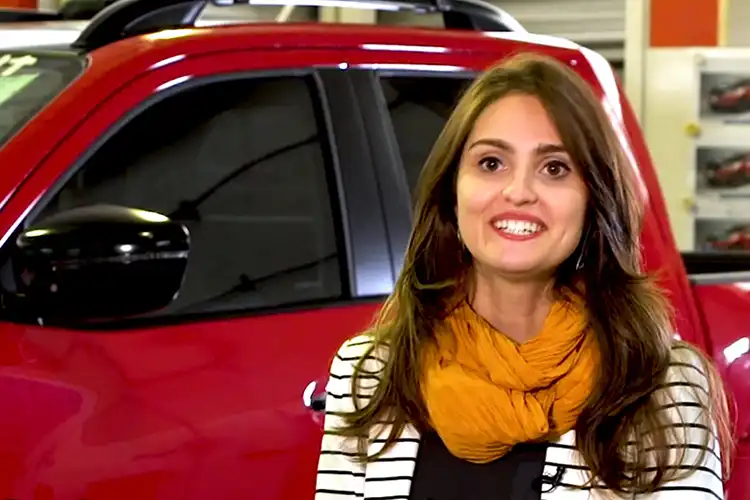 Uma mulher parada na frente de um caminhão vermelho