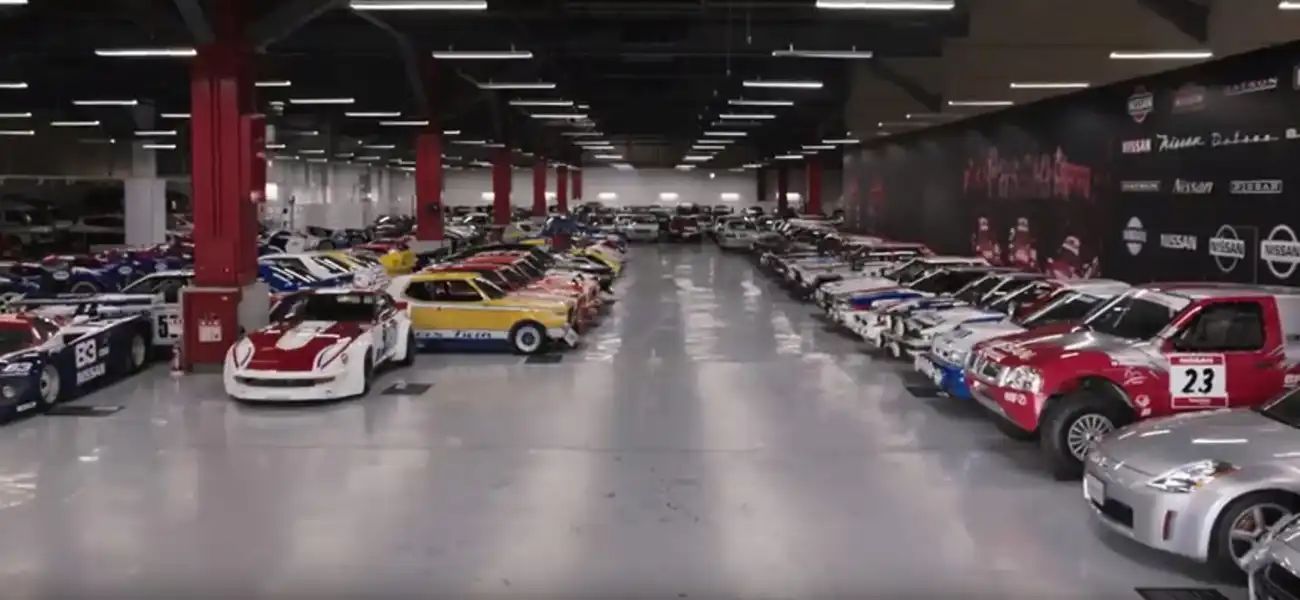 Nissan’s iconic cars throughout the past eight decades displayed in a large room.