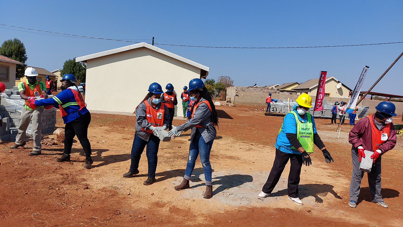 Group of women working on building homes.