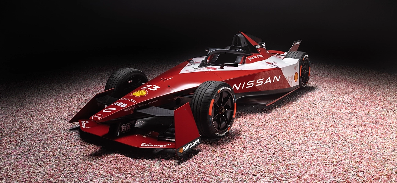 Carro de corrida da Equipe Nissan de Fórmula parado de 3/4 com fundo escuro