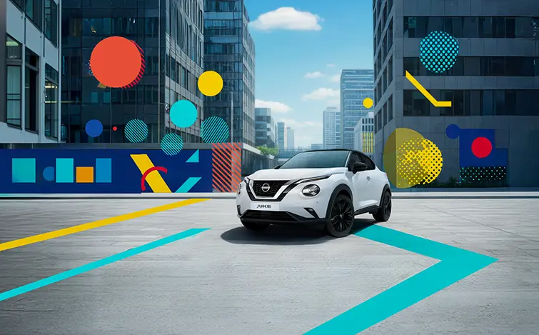 Nissan Juke N-Style blanc avec toit noir de ¾ avant avec tout autour des éléments graphiques colorés