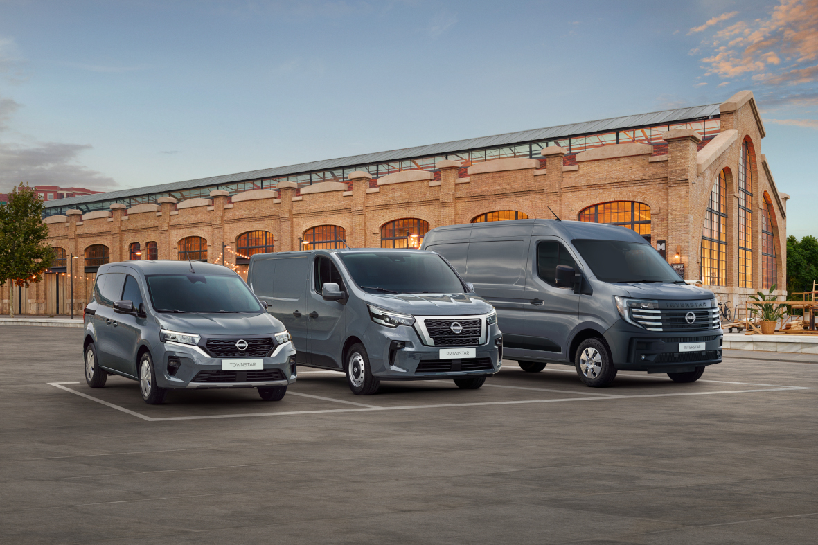 Szare Nissany Townstar, Primastar i Interstar z ceglanym budynkiem w tle