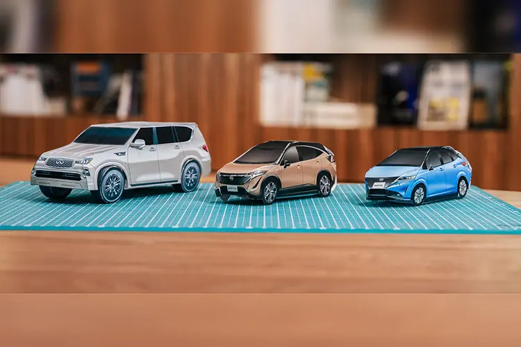 Close up of three model cars made of paper on a table