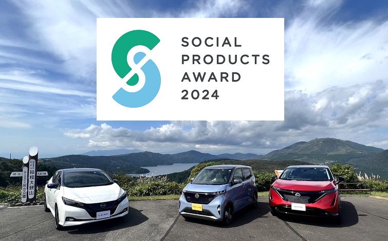 青空の芦ノ湖のパノラマを背景に、日産のEV（左より）リーフ（白）、サクラ（水色）、アリア（赤）が手前を向いて停車している画面中央に、SOCIAL PRODUCTS AWARD 2024のロゴ