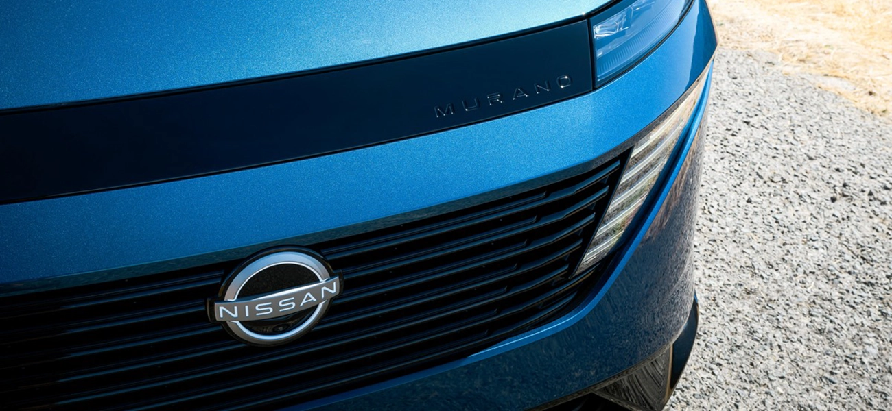 Close up of the front half of the grill and headlights on a blue 2025 Nissan Murano.