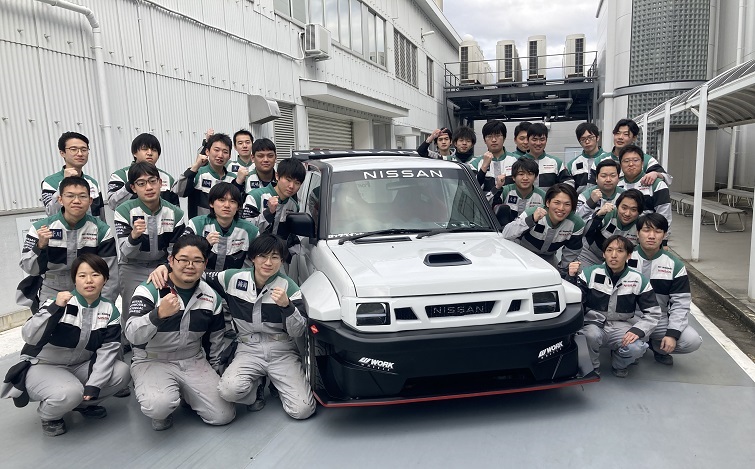 KOTOを囲んで集合写真！日産京都自動車大学校の学生たち（学校指定のつなぎ姿）