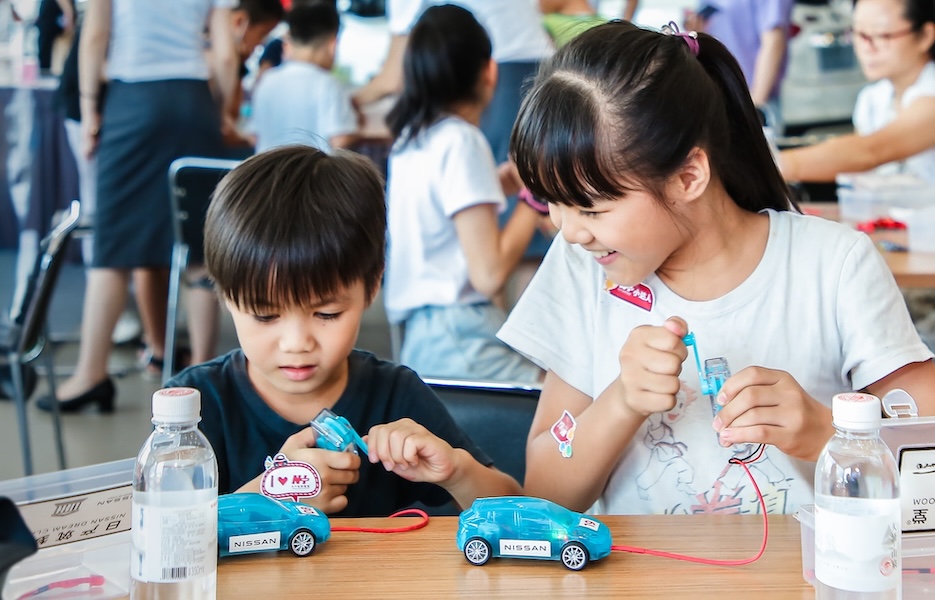 children in a classroom playing with hydrogen car kits