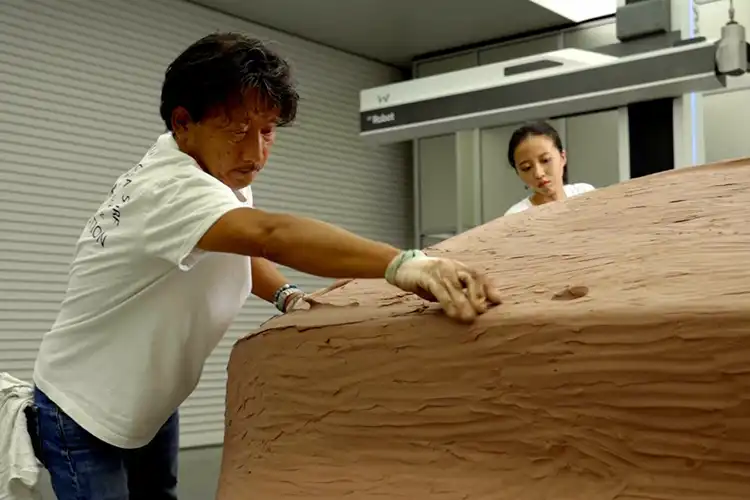 un señor con bloque de arcilla creando un modelo