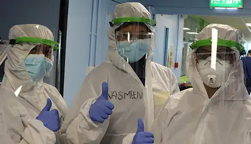 Three people standing in PPE for the fight against COVID-19