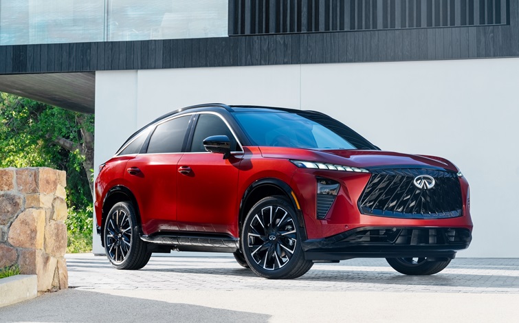 The QX65 with a red exterior body and black roof is shown parked in front of modern architecture.