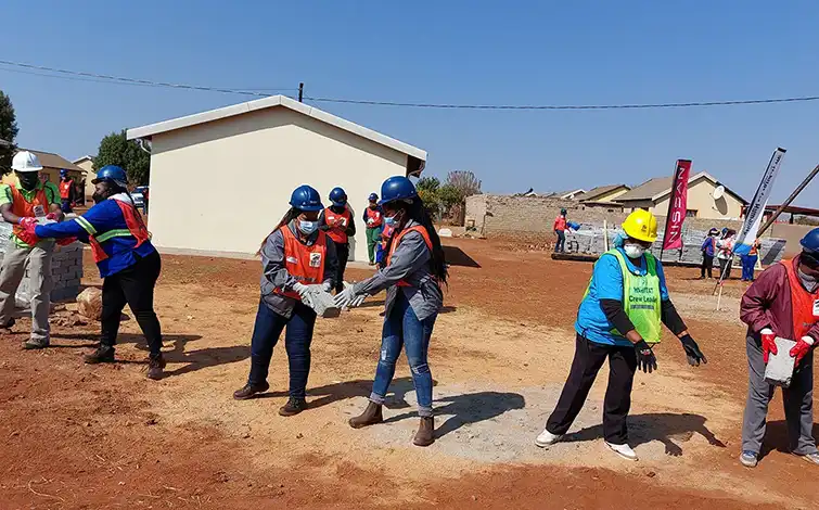 Group of women working on building homes.