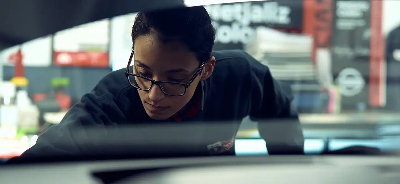An image of Nelly Colón working on a car.