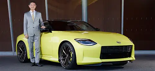 Hiroshi Tamura standing next to yellow car