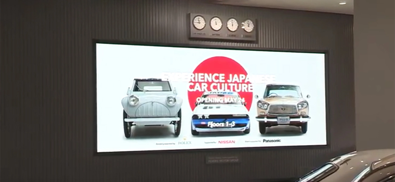 An image of a screen from an exhibit that shows 3 cars.