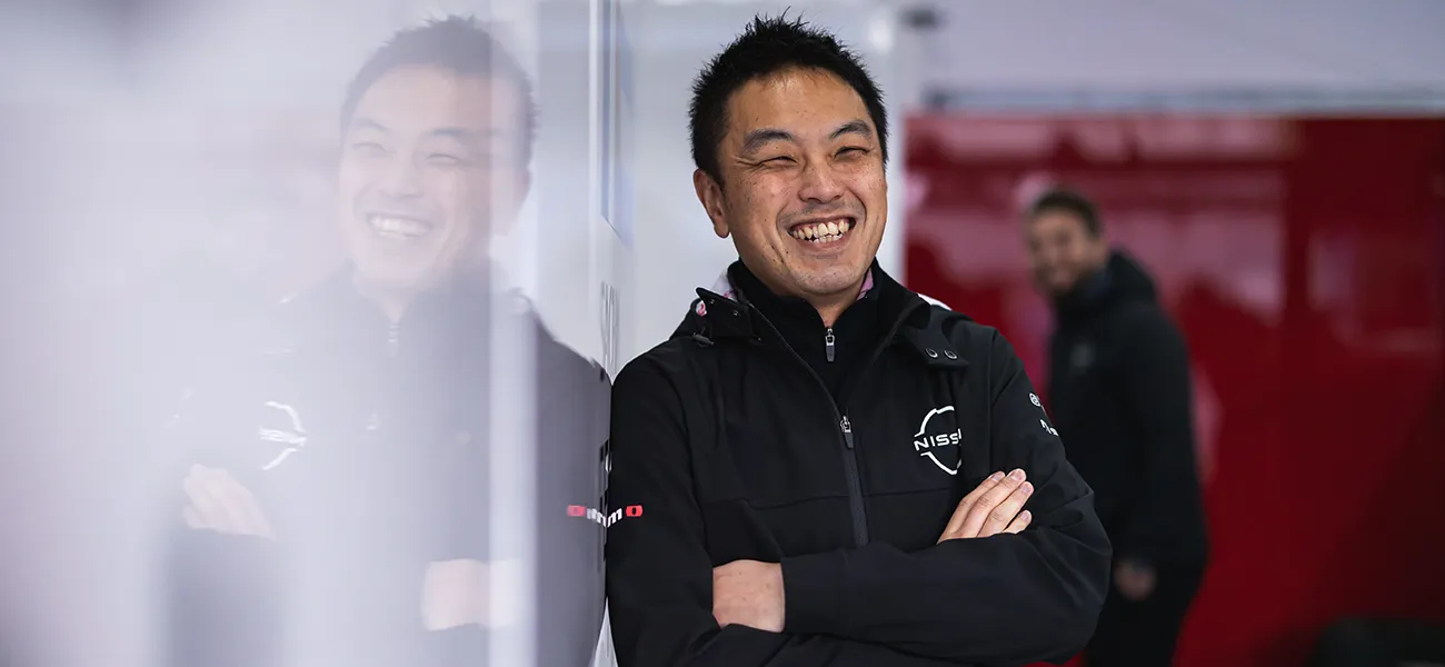 Tadashi Nishikawa, Chief Powertrain Engineer at Nissan Motorsports, leaning on a wall