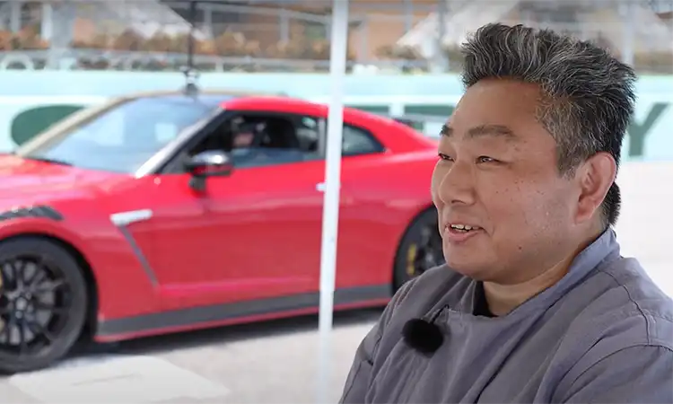 A side profile of a man in front of a red GT-R.