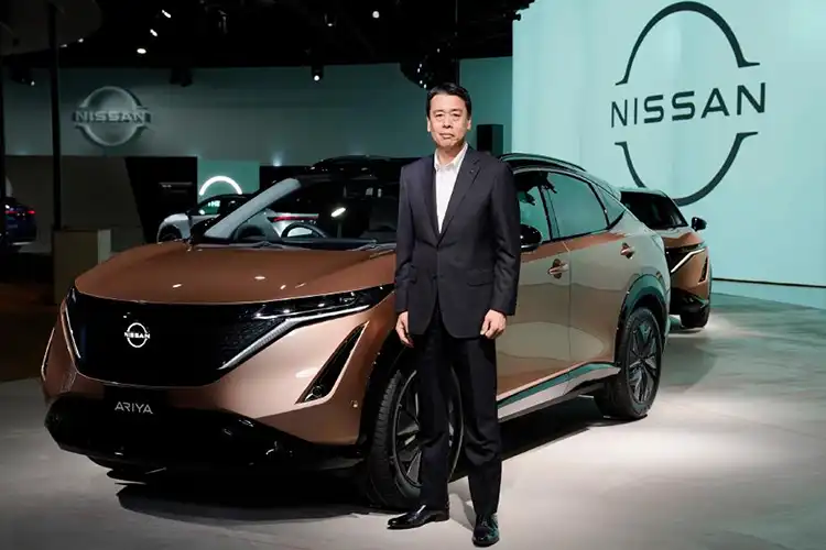 Um homem posando na frente de um carro no palco