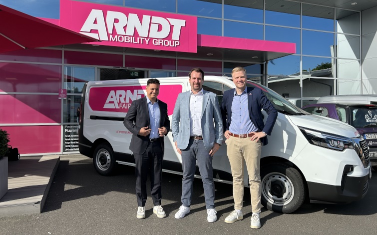 Drei Männer stehen vor einem Nissan Primastar, der wiederum vor einem Gebäude mit der großen Aufschrift Automobile Arndt geparkt ist