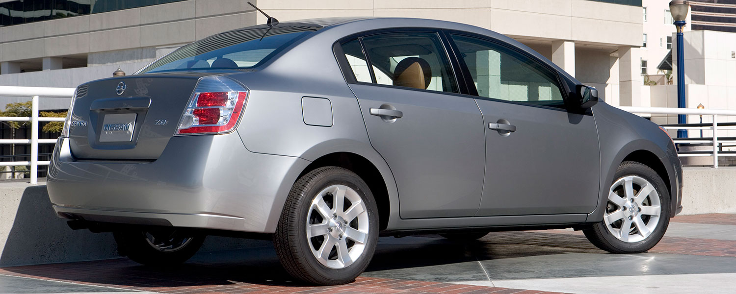 A silver 2007 Nissan Sentra parked near some buildings