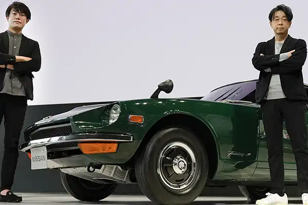 Naoyuki Ohkoshi and Takuya Yamashita pausing in front of a green Nissan Z.