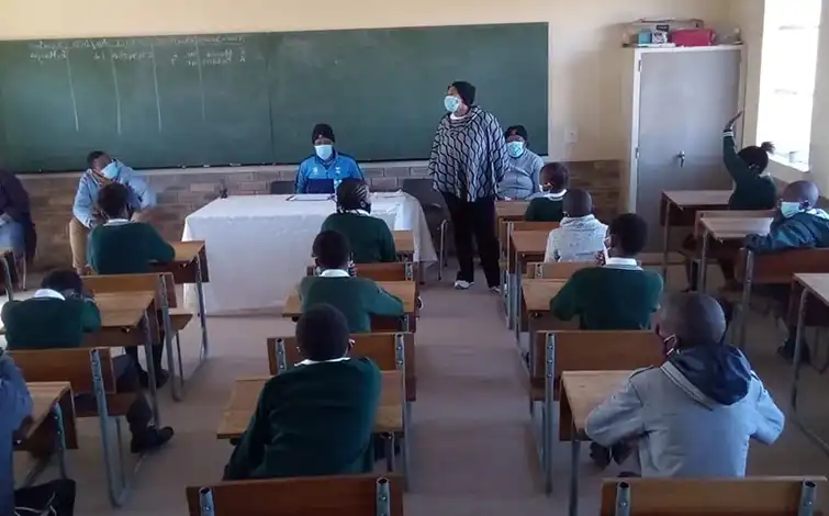 Children sitting in a classroom wearing face masks.