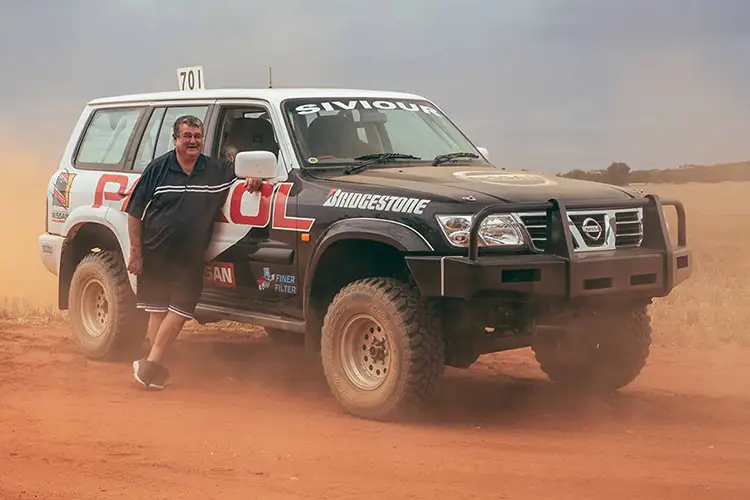 Lee Siviour standing in front of his Naissan Patrol in the barren outback.